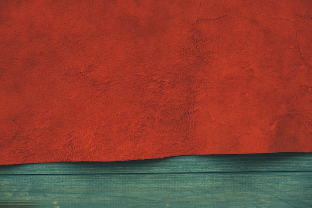 Red matte background of suede fabric. Velvet texture of seamless leather. Felt material.