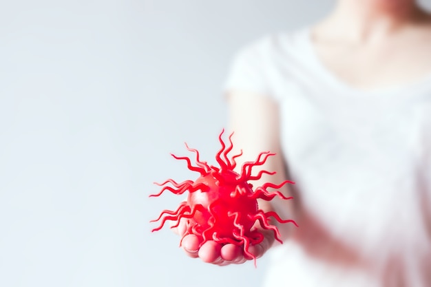 Red model of virus lies on person's hand on white background. Theme of Hygiene and handshake virus spread.