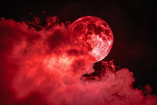 Photo a red moon with pink smoke on a black background in the concept of copy space