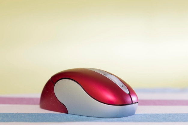 Red mouse inhalambrico for computer perched on a striped surface