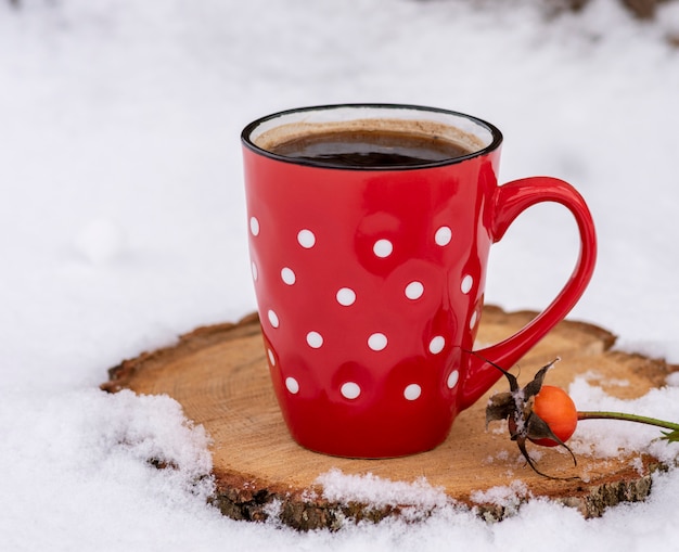 Red mug in a white dot with hot black coffee