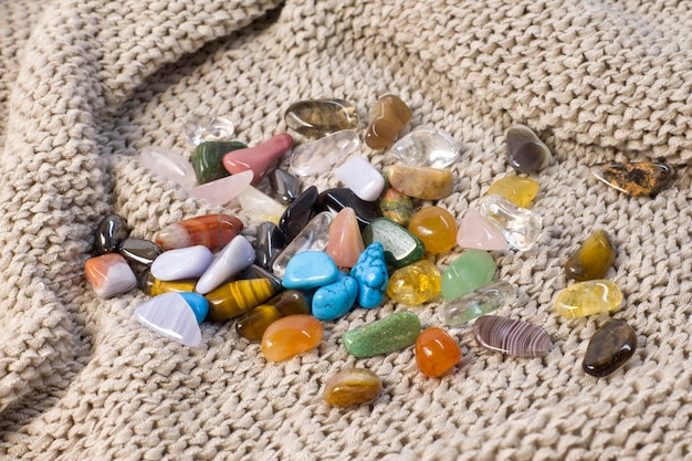 Red and multicolored jasper polished tumblestones on pink background