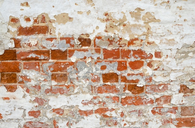 Red Old Weathered Brick Wall With Beaten Pieces Of Whitewash, Putty And Plaster Background