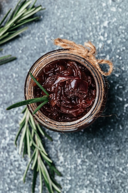 Red onion marmalade jam confiture in jar Vegetable jam on dark background Delicious sauce French cuisine Food recipe background space for text