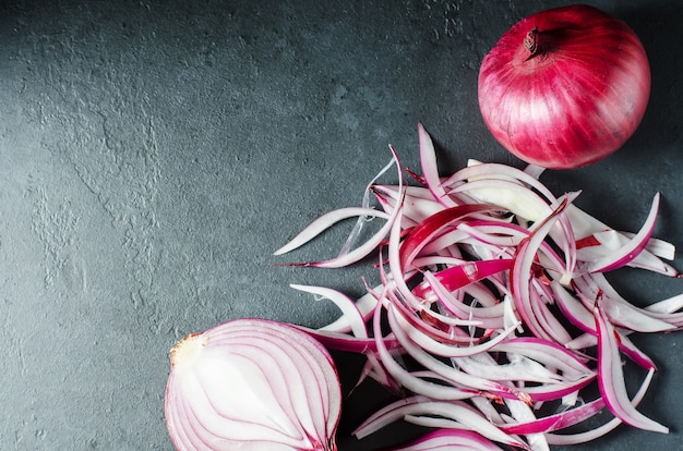 Red onion and sliced onion on a wooden chopping Board. Side view. Flat top view. Copy space