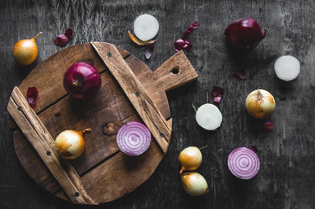 Red Onion Slices on wooden board with dark background