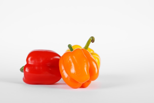 Red and orange color peppers on white