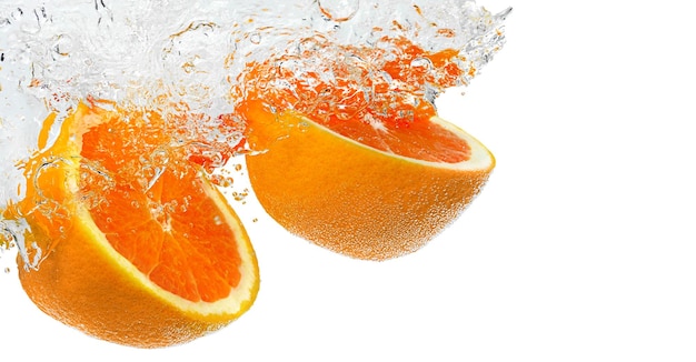 Red Oranges halves falling in water with splash on white background