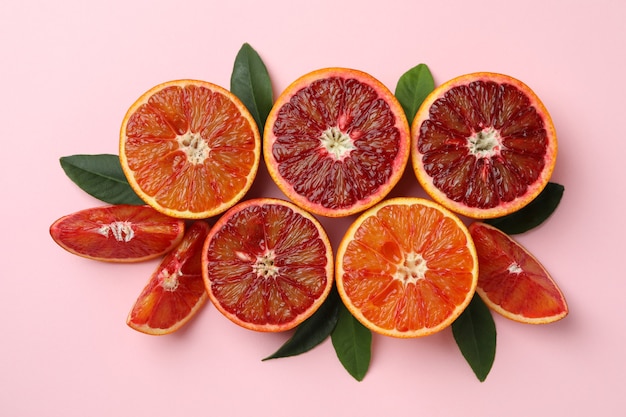 Red oranges and leaves on pink