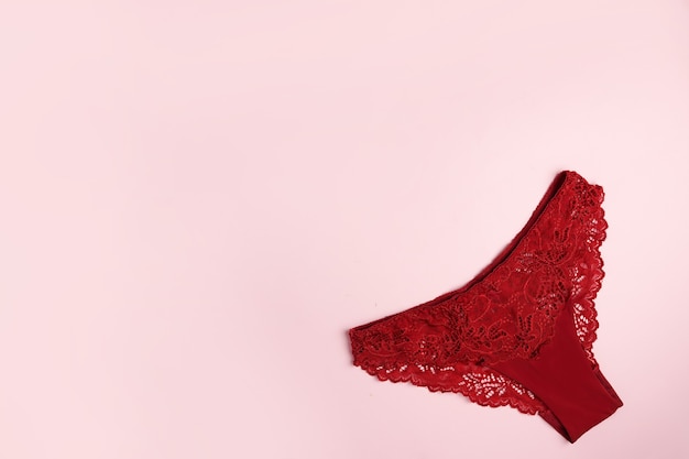 Red panty with lace on pink background with copy space