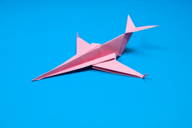 Red paper airplane on blue