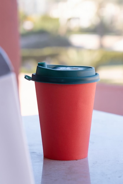 red paper coffee cup on coffee table in the balcony