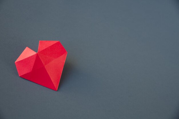 Red paper heart origami isolated on a grey background