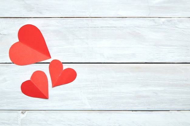 Red paper hearts on white wood Valentine's Day