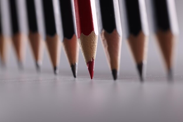 Red pencil stands out from many identical black ones