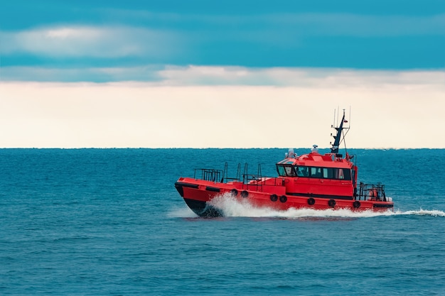 Red pilot ship moving at speed from Baltic sea