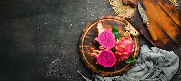 Photo red pitahaya on a black background fruit dragon tropical fruits top view free space for text