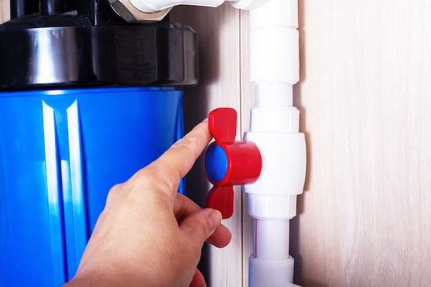 Red plastic faucet on white water pipe