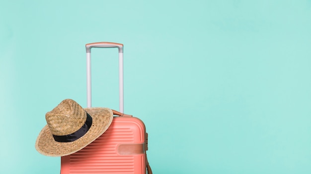 Red plastic suitcase with hat