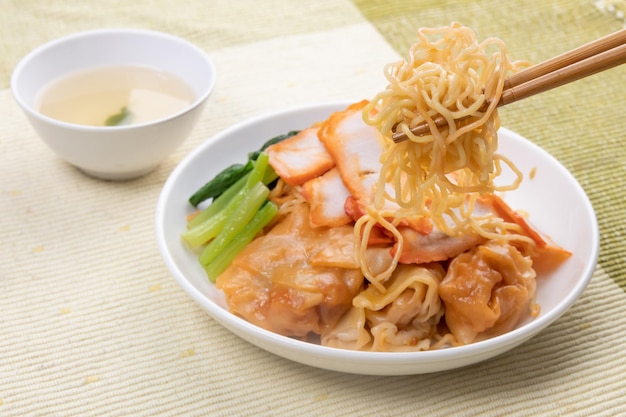 Red pork wonton noodles on a white plate ready to eat, Thai street food.