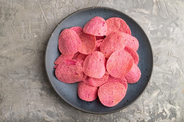 Red potato chips on gray concrete background Top view close up