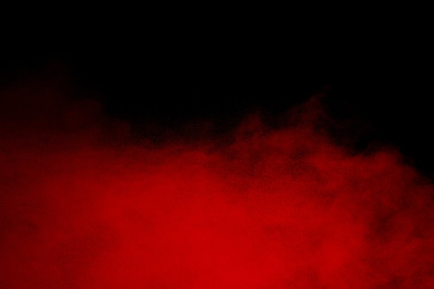 Red powder explosion cloud on black background.