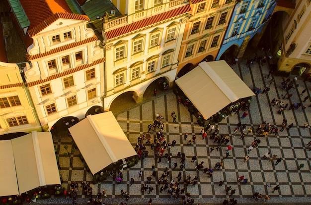 Red Prague roofs and square with lot of small people - view from the City Hall, travel european background