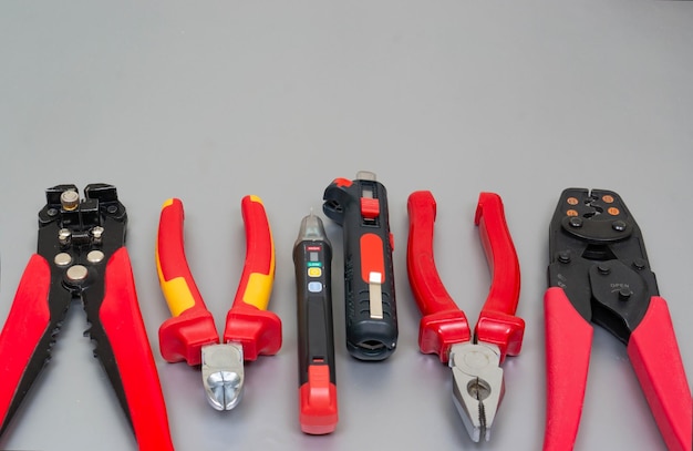 Red professional electrician tools on silver grey background