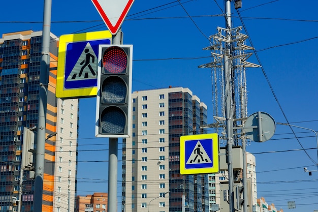 Red prohibition signal of traffic light on the background of highrise buildings