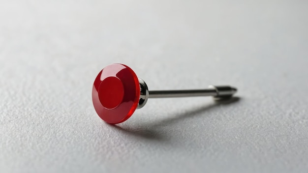 Red Push Pin on White Surface