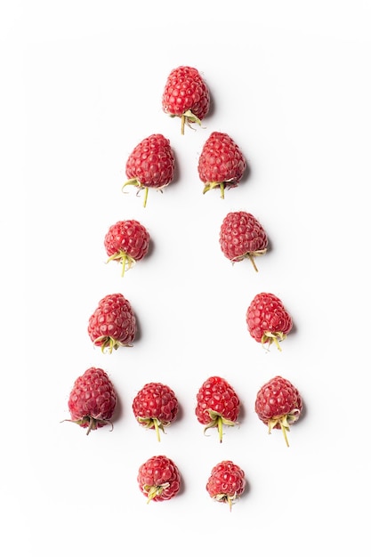 Red raspberries on white in shape of Christmas tree