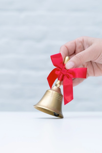 Red ribbon bell book golden white background school hand hold