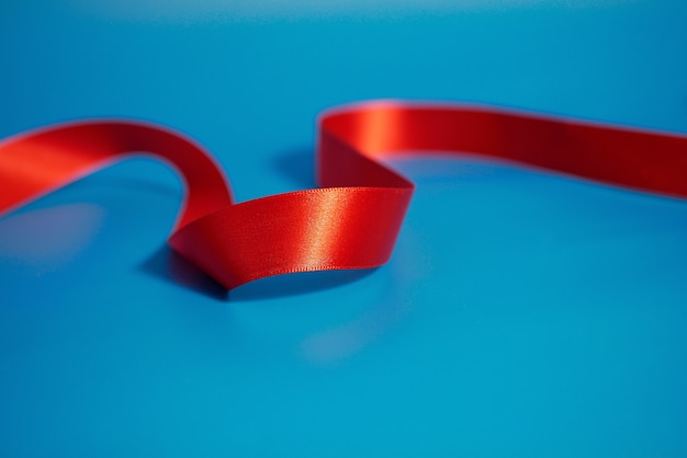 Red ribbon on blue surface