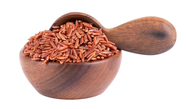 Red rice isolated in wooden bowl and spoon on white background Whole grain raw brown rice