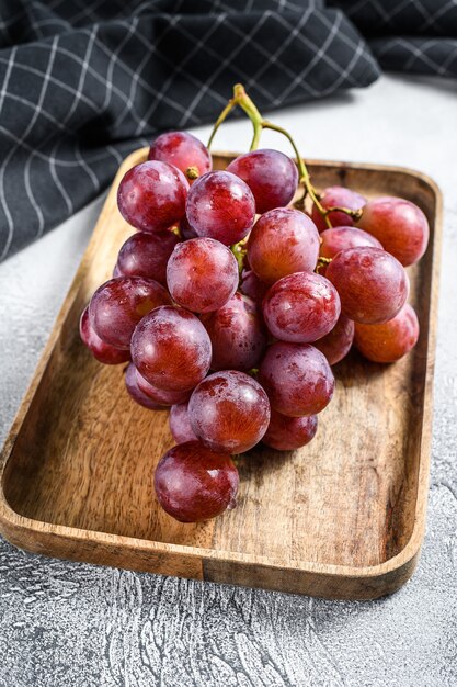 Red ripe grapes in a wooden bowl