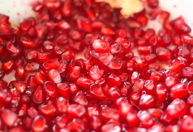 Red ripe pomegranate grains on white background.