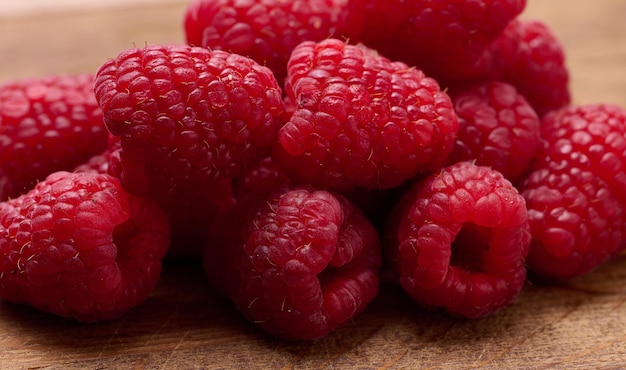 Red ripe raspberries on wooden