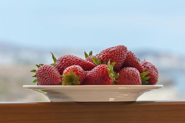 Red ripe strawberries on a plate Blurry background closeup