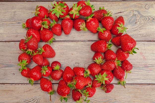 Red ripe strawberries on wooden table close up