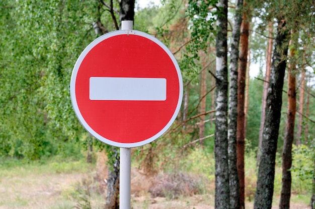 Red road sign Entry is prohibited against the background of the forest closeup