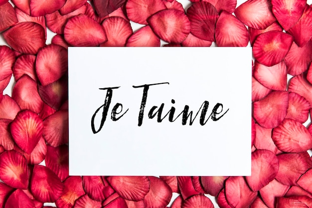 Red rose petals with je taime message