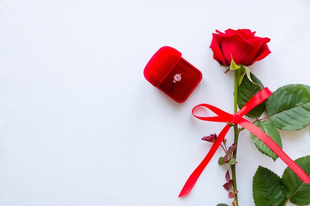 Red rose tied bow and wedding ring