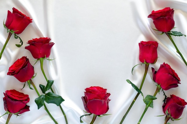 Red roses put on white satin cloth background for anniversary mother and Valentine day concept