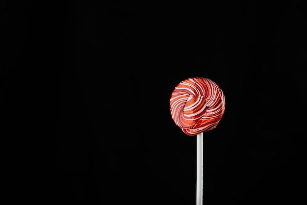 Red round colored Lollipop on black background