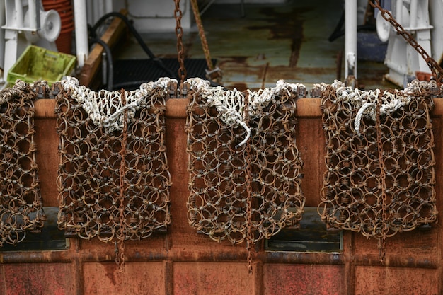 Red rusty boats and metal nets for catching scallops