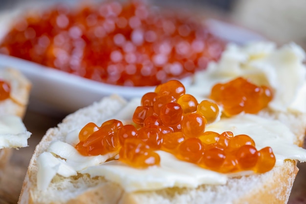 Red salmon or trout caviar with white baguette and butter