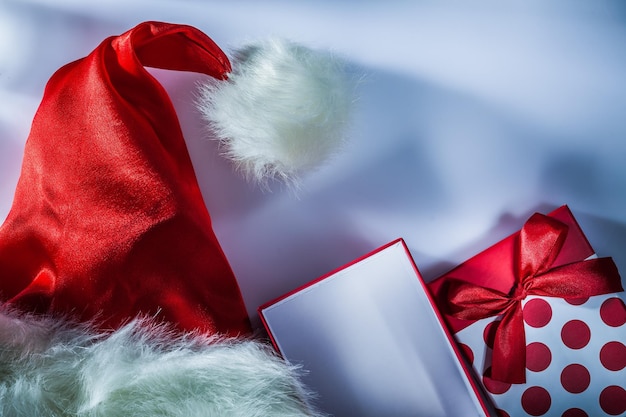 Red Santa Claus cap present box on white surface