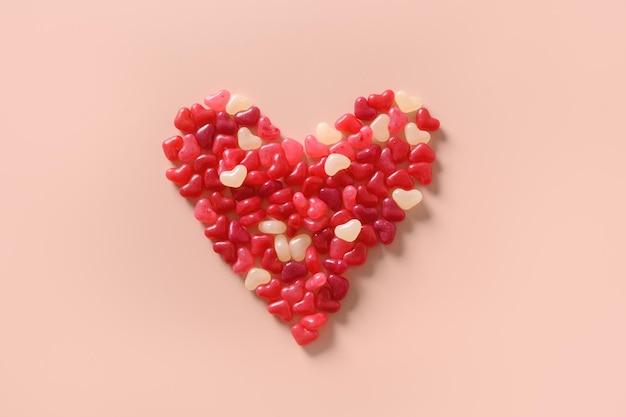 Red shaped heart of sweets on pink background Valentines day