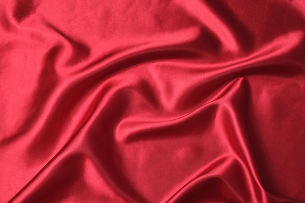 Red shiny satin fabric background with nice wrinkles