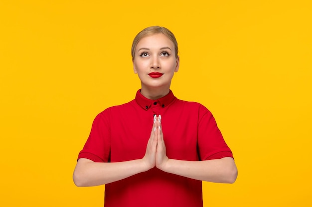 Red shirt day cute girl holding hands together and praying in a red shirt on a yellow background